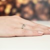 Delikatny pierścionek zaręczynowy z białego złota w kształcie serca z brylantem, prezentowany na dłoni z delikatnym tłem produktu W0188.B3.DIW.01