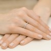 Delikatny pierścionek z białego złota wysadzany drobnymi brylantami, prezentowany na dłoni produktu W0425.B3.DIW.01