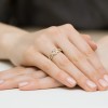 Złoty podwójny pierścionek serce z cyrkoniami knot ring, prezentowany na dłoni produktu EP012-333