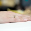 Złoty pierścionek z żółtego złota z diamentem, prezentowany na dłoni z jasnym tłem produktu W0088.Z3.DIW.04