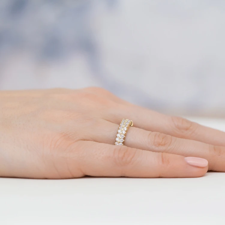 Złoty pierścionek z białymi kamieniami, prezentowany na dłoni produktu EP039-333-B