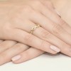 Pleciony złoty pierścionek z cyrkoniami, prezentowany na dłoni z delikatnym manicure produktu W0096.Z3.DIW.01